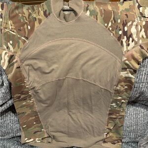 Military Grade Mock Neck Camo Long Sleeve Shirt with a lot of zippered pockets.